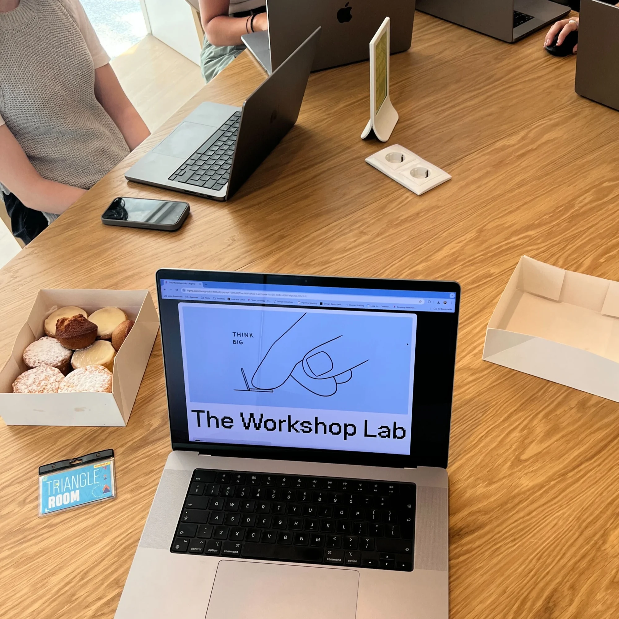 Workshop table with laptops and a screen showing a sketch for The Workshop Lab.
